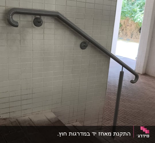 מעקה מתכת על קיר ליד מדרגות